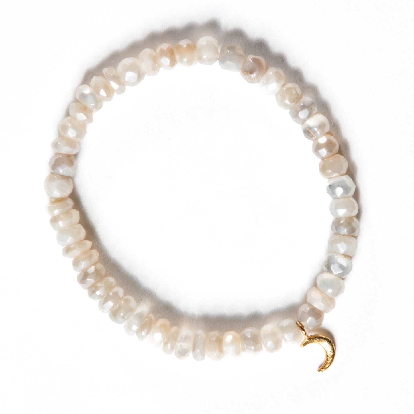 Handmade elastic moonstone bead bracelet in a beautiful pearlescent cream hue, with sparkling faceted stones and a gold crescent moon charm. This sacred moonstone jewelry is a talisman for travelers, a stone of prophecy, and a symbol of new moon phases.
