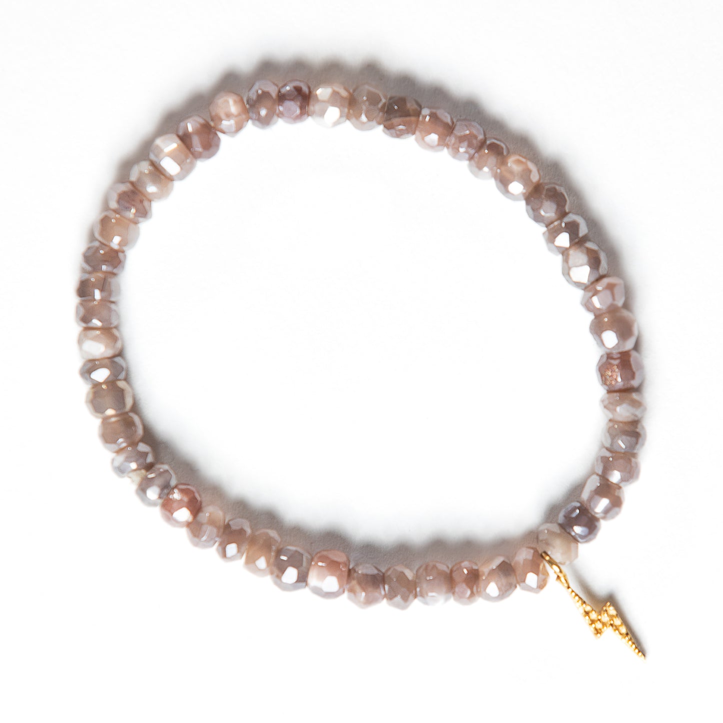 Handmade taupe-colored moonstone bead bracelet with sparkling faceted stones and a gold lightning bolt charm. This sacred moonstone jewelry acts as a talisman, bringing true love and embodying powerful, inspiring energy.